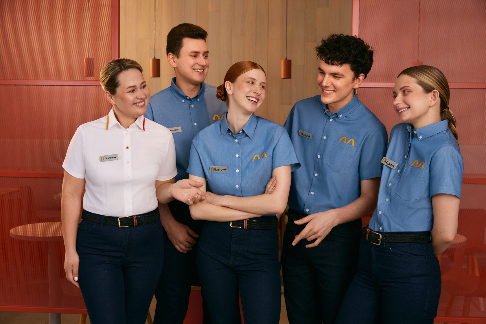 McDonald's crew members smiling and giving a high five outside the restaurant